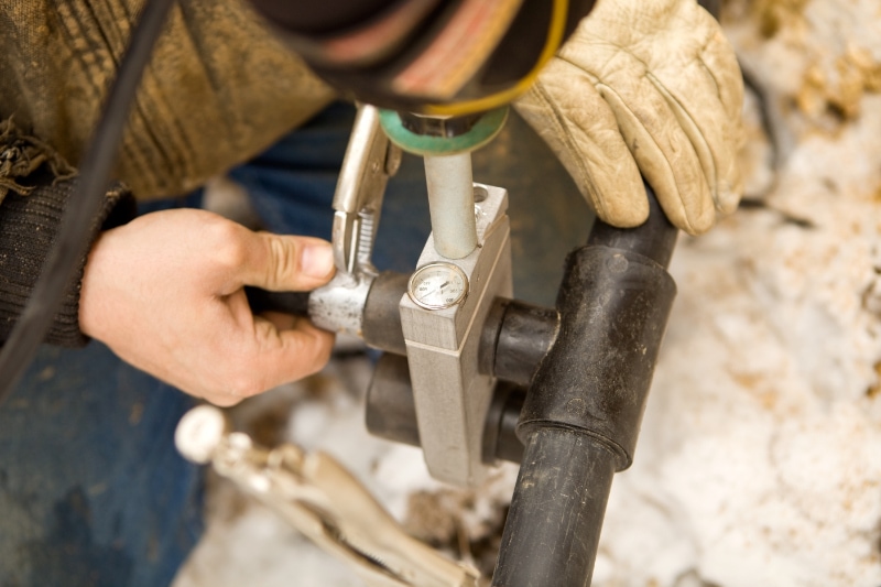 Two Workers Join Residential Geothermal Heating/Cooling Pipe.