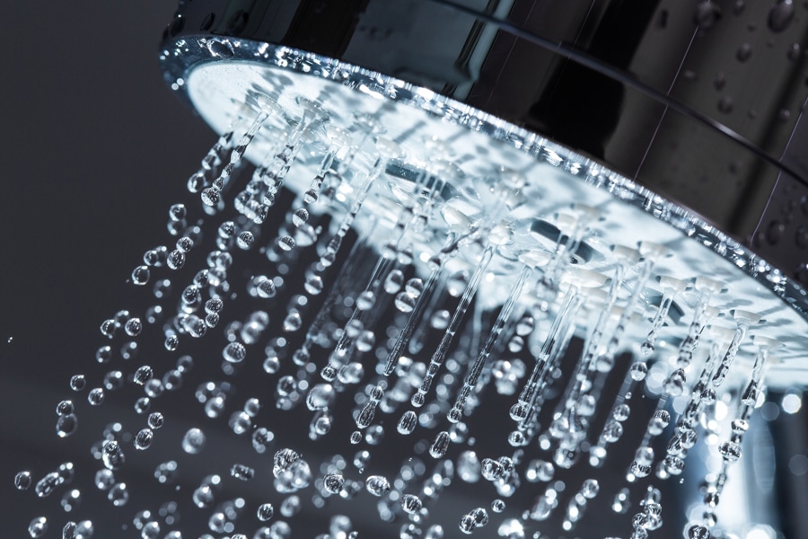 close-up of a shower head spraying water.